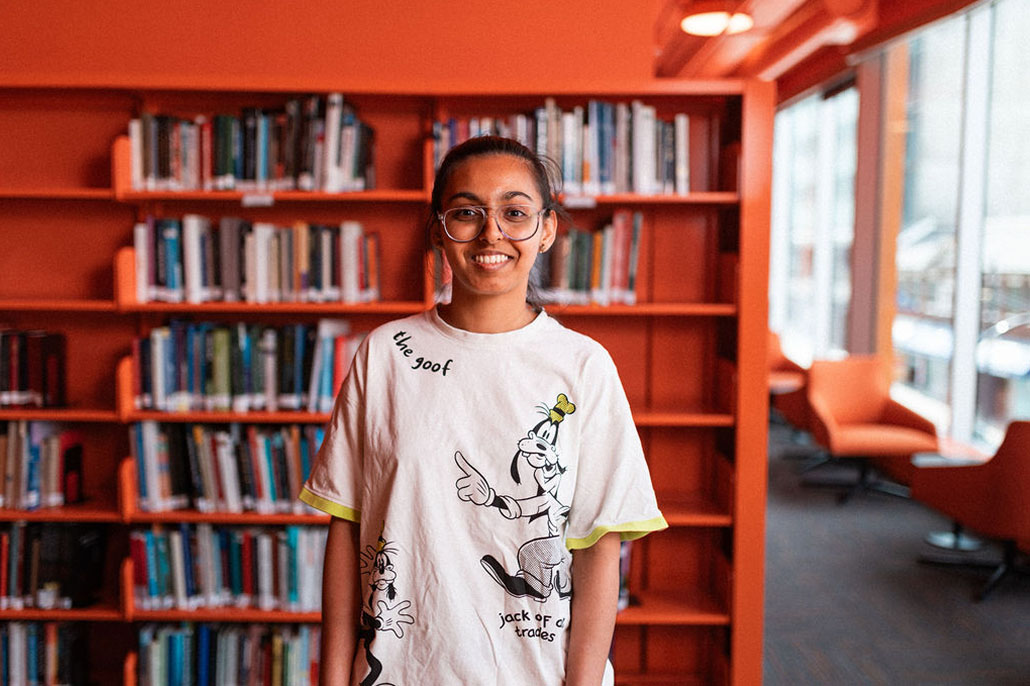 An Adler University student smiles in the library of the Vancouver campus.